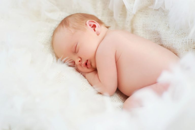 A Newborn Baby Sleeping in a Feather Nest